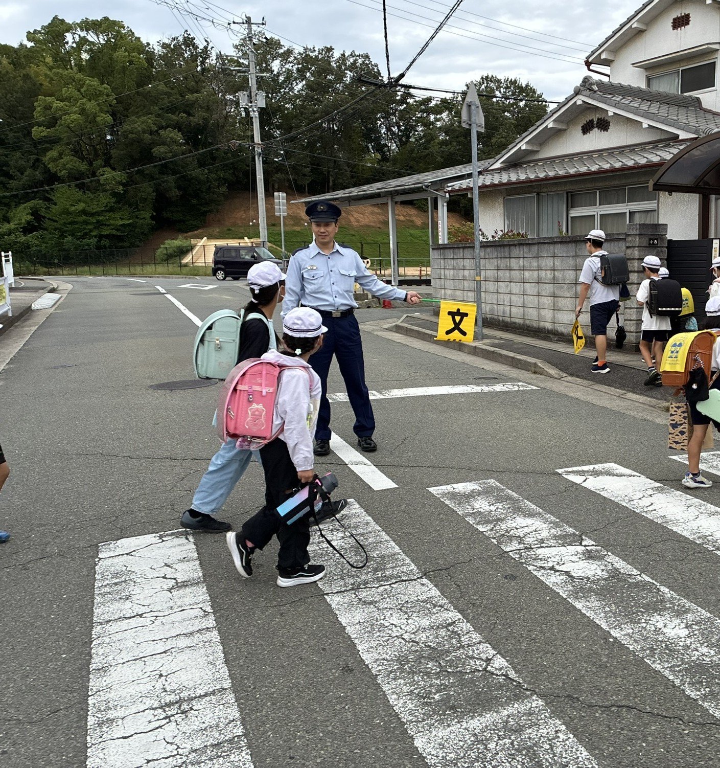 通学路で子どもたちを見守る刑務官
